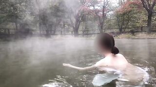 Bathing scene in a huge mixed outdoor hot spring bath.